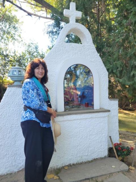 Gail DeGeorge poses near the brook where Lydia was said to have been baptized and where the tour group celebrated Mass.